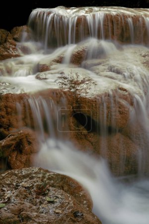 Water flows softly at Than Sawan Waterfall in Doi Phu Nang National Park of Phayao Province, Thailand.