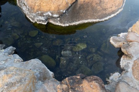 Oben Blick auf Stein und Wasser. Heiße Quellen mit grünen Mineralien unter dem Wasser. Im Chae Son Nationalpark Thailand.