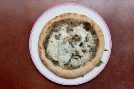 Above view of Pizza topped with truffle mushrooms and dense cheese. Arrange on a round plate. and placed on a red background