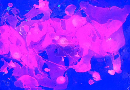 Fondo abstracto. Manchas rosadas caóticas se derraman dinámicamente sobre un fondo azul. Colores brillantes. Círculos, olas, líneas. Salpicaduras y desenfoque. Diferentes tonos de rosa y púrpura.