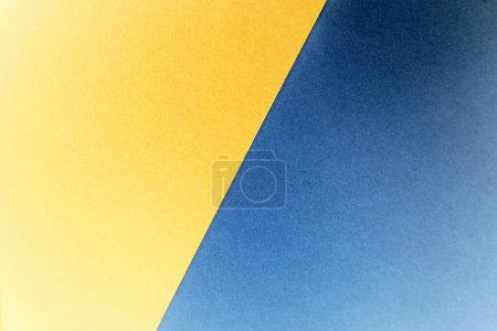 Abstrakter Hintergrund. Das Foto ist diagonal in zwei Farben aufgeteilt. Blau und Gelb. Farben haben einen Farbverlauf. In der oberen rechten Ecke sind sie dunkler, an den Rändern wird der Hintergrund heller