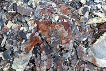 Photo for Photo of stone texture. Macro. Various shades of brown, orange, red, gray and white. Stones of different sizes. They have black cracks and crevices. Chaotic placement. - Royalty Free Image
