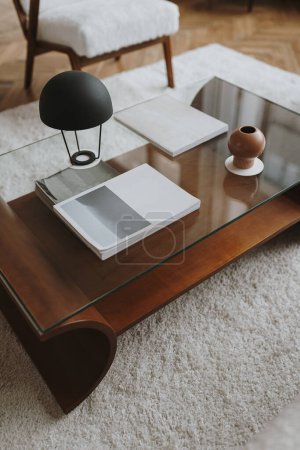 Foto de Mesa de centro de madera en elegante salón interior con sillón vintage, alfombra, lámpara de mesa - Imagen libre de derechos