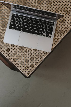 Flatlay von Laptop-Computer auf Luxus-Rattan-Liegestuhl. Arbeit zu Hause, freiberuflich, Online-Shopping, Online-Shop, Blog, Social Media Branding-Konzept