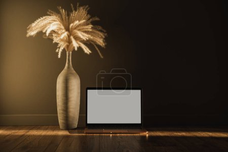 Photo for Online shopping, online store template. Laptop computer with blank copy space screen. Aesthetic minimal pampas grass floral bouquet against shaded wall. Shadows on the wall. Silhouette in sunlight - Royalty Free Image