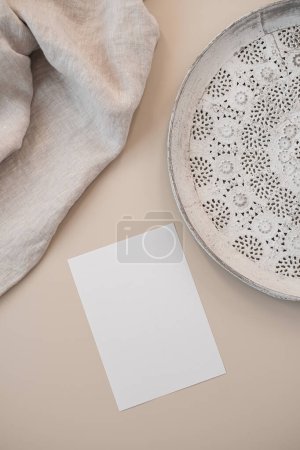 Photo for Blank paper card with mockup copy space, elegant tray, crumpled blanket on beige background. Top view, flat lay minimalist aesthetic brand template - Royalty Free Image