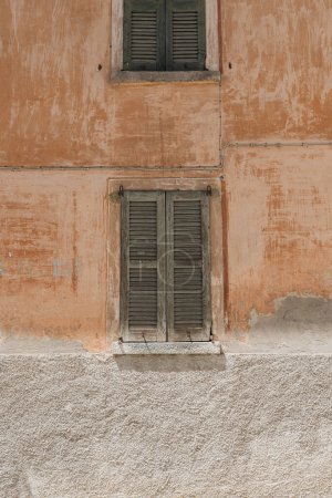 Téléchargez les photos : Façade murale en corail et fenêtre en bois avec volets. Abstrait Design architectural italien - en image libre de droit