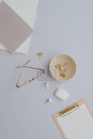 Photo for Glasses, clipboard, headphones, gold accessories on white background with blank mockup copy space. Flat lay, top view minimalist home office desk workspace template - Royalty Free Image