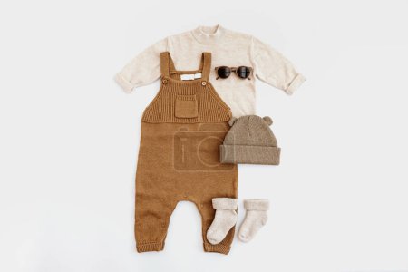 Foto de Acogedor cálido nórdico elegante pastel colorido recién nacido ropa y accesorios sobre fondo blanco. Estética minimalista bebé moda conjunto - Imagen libre de derechos