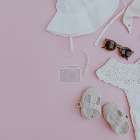 Foto de Conjunto de ropa de verano lindo y accesorios para niña sobre fondo rosa. Colocación plana, vista superior de la colección de moda elegante para el bebé pequeño - Imagen libre de derechos