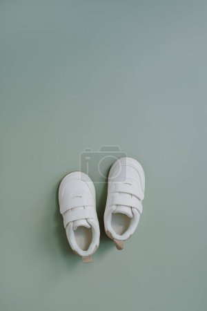 Téléchargez les photos : Baskets blanches pour bébé. Pose plate de vêtements scandinaves nordiques pour enfants. Couleur pastel neutre esthétique - en image libre de droit
