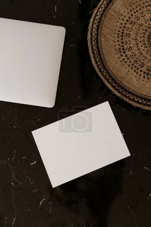 Photo for Blank paper invitation card with copy space and laptop. Flat lay, top view aesthetic minimalist wedding invitations - Royalty Free Image