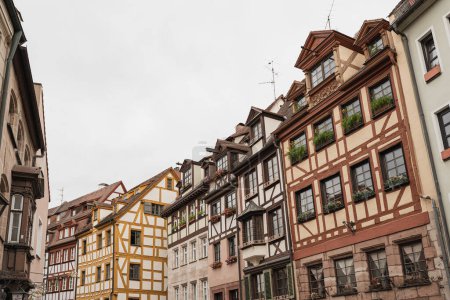 Photo for Old historic architecture in Nuremberg, Germany. Traditional European old town buildings with wooden windows, shutters and colourful pastel walls. Aesthetic summer vacation, tourism background - Royalty Free Image