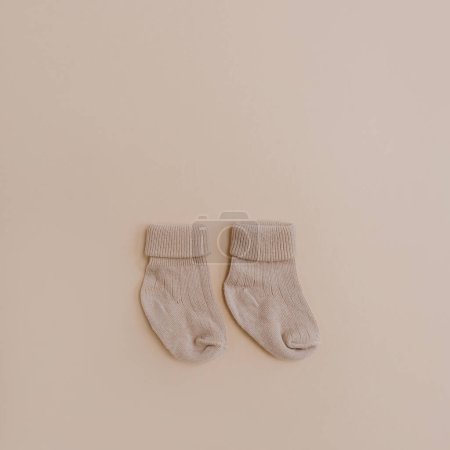 Photo for Pair of cozy hygge pastel colourful newborn baby socks on neutral beige background. Aesthetic minimalist baby fashion collage. Happy maternity concept - Royalty Free Image