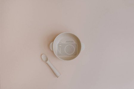 Photo for Flat lay of cute baby tableware. Plate bowl and spoon on neutral background. Baby serving first food accessories. Flat lay, top view nutrition and feeding concept - Royalty Free Image