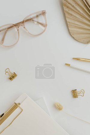 Photo for Flatlay blank copy space. Clipboard, tan fan leaf, glasses, clips on white background. Home office desk workspace. Aesthetic business, work template. Flat lay, top view - Royalty Free Image