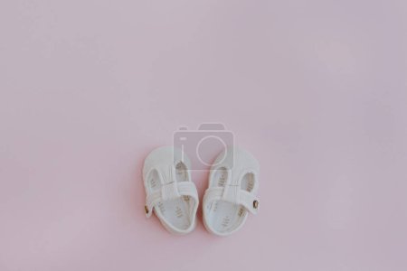 Photo for Cotton shoes for baby child. Flat lay of aesthetic nordic Scandinavian fashion children's wearing. Neutral pastel pink colour - Royalty Free Image