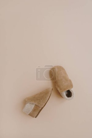 Photo for Warm winter children's mini booties. Baby shoes on neutral beige background. Fashion Scandinavian children's clothes. Flat lay, top view. - Royalty Free Image