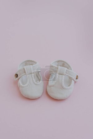 Photo for Pair of children's mini shoes on neutral pastel pink background. Flat lay, top view stylish Scandinavian baby clothing - Royalty Free Image