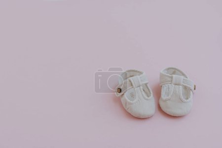 Foto de Mini sandalias para niños recién nacidos. Zapatos de bebé sobre fondo rosa pastel. Moda Ropa infantil escandinava. Piso tendido, vista superior - Imagen libre de derechos