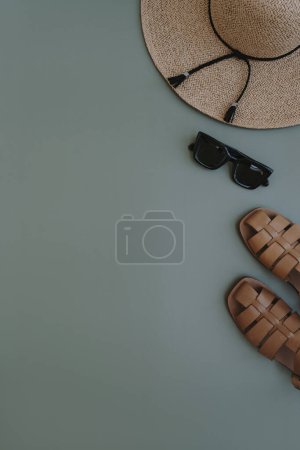 Photo for Flatlay of aesthetic women's fashion accessories. Stylish female sunglasses, straw hat, sandals on pastel blue copy space background. Top view, flat lay - Royalty Free Image
