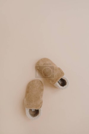 Photo for Warm winter suede booties for baby child. Flat lay of nordic Scandinavian fashion children's wearing. Aesthetic neutral pastel beige colour - Royalty Free Image
