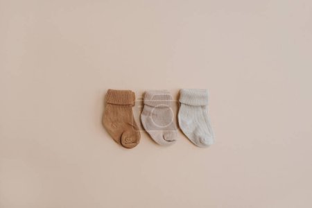 Photo for Cozy hygge pastel colourful newborn baby socks on neutral beige background. Aesthetic minimalist baby fashion collage. Happy maternity concept - Royalty Free Image