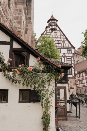 Téléchargez les photos : Ancienne architecture historique à Nuremberg, Allemagne. Bâtiments européens traditionnels de vieille ville avec des fleurs. Esthétique concept de voyage d'été - en image libre de droit