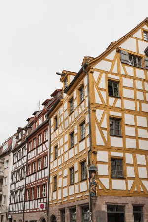 Alte historische Architektur in Nürnberg, Deutschland. Traditionelle europäische Altstadtgebäude mit Holzfenstern, Fensterläden und bunten Pastellwänden. Ästhetischer Sommerurlaub, touristischer Hintergrund