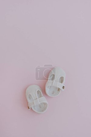 Photo for Pair of children's mini shoes on neutral pastel pink background. Flat lay, top view stylish Scandinavian baby clothing - Royalty Free Image