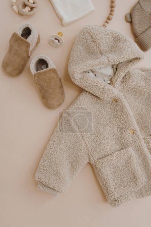 Téléchargez les photos : Flatlay esthétique scandinave vêtements pour bébés, accessoires, jouets collage sur fond beige pastel neutre. Tendance élégante couleur neutre chaud hiver affaires pour enfants. Vue du dessus - en image libre de droit