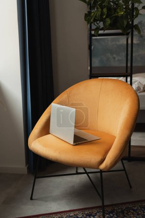 Foto de Ordenador portátil en un cómodo sillón. Trabaja en casa. Espacio de trabajo freelancer - Imagen libre de derechos