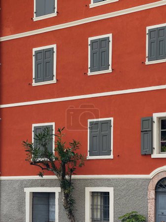 Téléchargez les photos : Architecture historique italienne. Ancien bâtiment rustique européen traditionnel avec murs rouges colorés, volets et fenêtres en bois - en image libre de droit