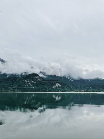 Foto de Pintoresca vista del lago con montañas y reflejos de nubes. Paisaje natural escénico. Vacaciones de verano en el parque nacional - Imagen libre de derechos
