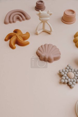 Photo for Stylish cute pastel colourful baby kid children educational toys on light pastel pink background. Aesthetic hygge baby toys collage with blank copy space. Teether, sand molds, stacking cups - Royalty Free Image