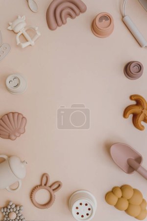 Photo for Set of baby kids toys for children. Educational toys in neutral pastel colors. Sand molds, bib, organic teethers, stacking cups on light pink background. Flat lay, top view empty blank copy space - Royalty Free Image