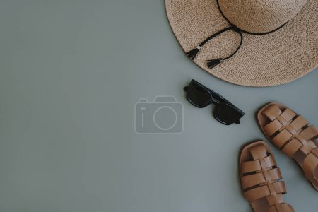 Téléchargez les photos : Flatlay d'accessoires de mode pour femmes esthétiques. Lunettes de soleil féminines élégantes, chapeau de paille, sandales sur fond bleu pastel. Vue de dessus, plan plat - en image libre de droit