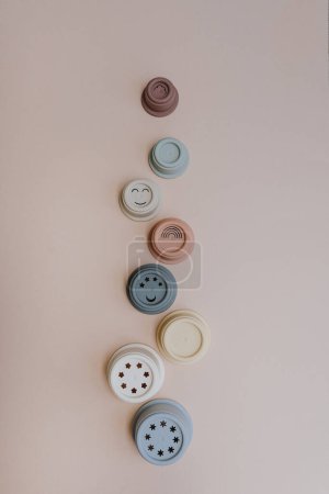 Téléchargez les photos : Modern Scandinavian nordic style baby toys on pastel pink background. Set of stacking tower cups in neutral pastel colors. Baby toys for playing with sand. Flat lay, top view - en image libre de droit