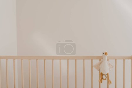 Téléchargez les photos : Jouet de canard dans un berceau contre un mur blanc - en image libre de droit