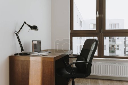 Téléchargez les photos : Espace de travail avec ordinateur portable, lampe, table, chaise. Travail, étude à domicile concept. Design d'intérieur de bureau moderne - en image libre de droit