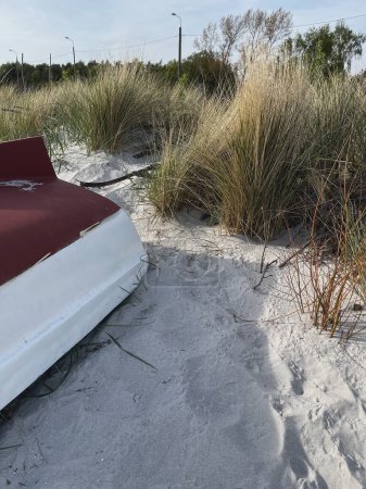 Téléchargez les photos : Bateau traditionnel en bois sur sable de plage. Herbe sèche sur la plage - en image libre de droit