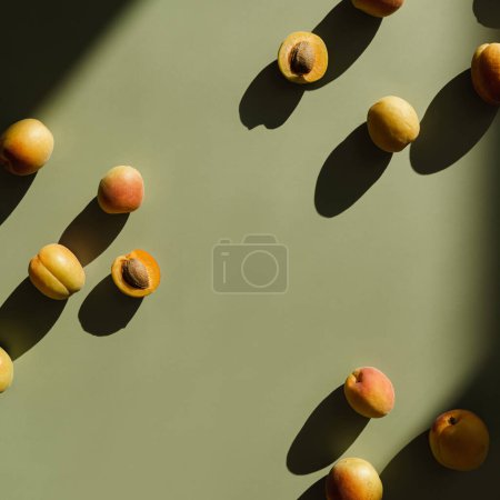 Photo for Fruit pattern of fresh peaches with sunlight shadows on neutral pastel green background - Royalty Free Image