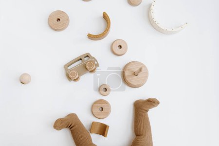 Photo for Baby's legs. Small cute baby playing with wooden toys. Top view, neutral beige colours - Royalty Free Image