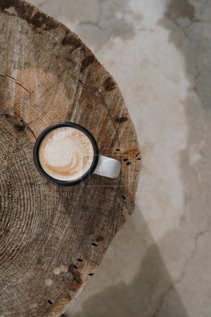 Foto de Taza plana con café con leche en la mesa de tocón de madera. Estética plana laico, vista superior bodegón concepto de estilo de vida - Imagen libre de derechos