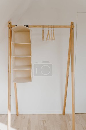 Téléchargez les photos : Cintres vides sur le cintre au sol au-dessus du mur blanc. Concept intérieur minimaliste avec garde-robe. Boutique de mode en ligne, fond de boutique en ligne - en image libre de droit