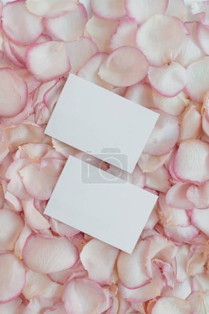 Foto de Tarjetas de hoja de papel en blanco con espacio de copia maqueta, pétalos de rosa rosa. Planta plana, vista superior estética mínima del Día de San Valentín - Imagen libre de derechos
