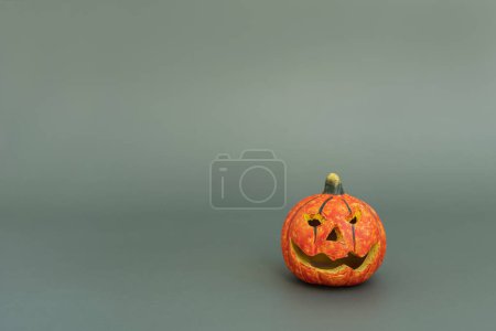 Foto de Colorida calabaza de halloween sobre fondo verde con espacio de copia. Concepto de vacaciones de otoño mínimo - Imagen libre de derechos