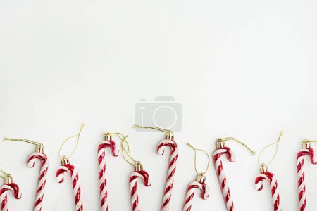 Téléchargez les photos : Esthétique minimaliste décoration de vacances de Noël. Des cannes à bonbons sur fond blanc. Carte de Noël - en image libre de droit