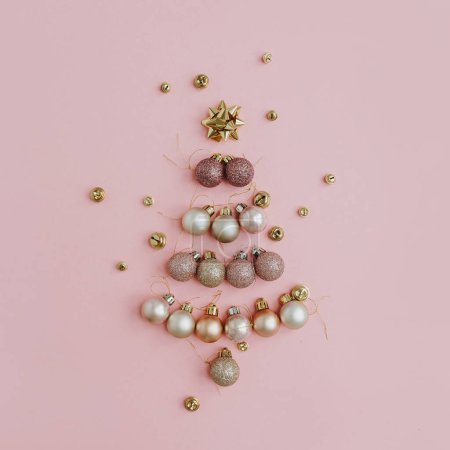Foto de Composición navideña. Árbol de Navidad hecho de colorida decoración de bolas sobre fondo rosa. Piso tendido, vista superior, espacio para copiar. Tarjeta de vacaciones de Año Nuevo - Imagen libre de derechos