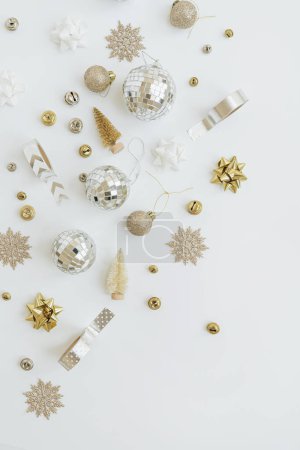 Foto de Disposición creativa estética de coloridas bolas de Navidad doradas, beige y juguetes sobre fondo blanco. Piso tendido, vista superior - Imagen libre de derechos